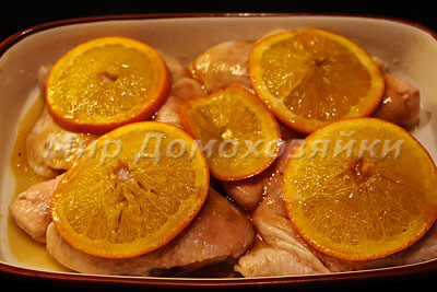 Апельсины уложить на куски курицы и запечь в духовке