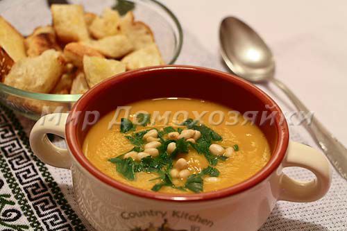 Подавать тыквенный крем-суп с сухариками и орешками